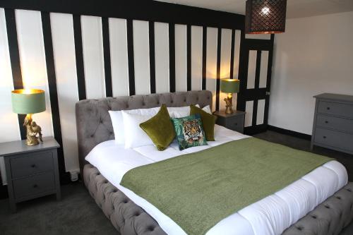 ein Schlafzimmer mit einem großen Bett und einer grünen Decke in der Unterkunft Luxury 3 Bed Apartment in the Heart of Stamford in Lincolnshire