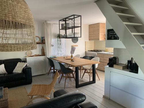 a kitchen and living room with a wooden table and chairs at "ZeeLandZon" Holiday home by the lake with Jacuzzi and Sauna in Herkingen