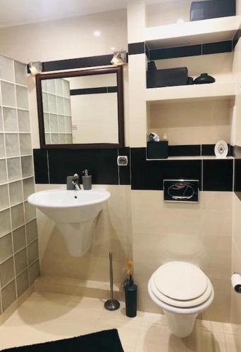 a bathroom with a white toilet and a sink at Swinoujscie Poland Luxury Penthouse Sleeps 9 in Świnoujście