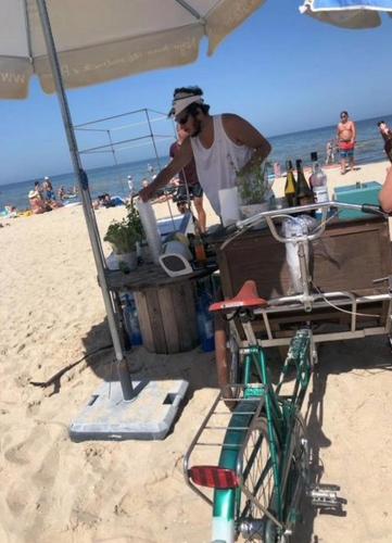 a man standing under an umbrella on the beach at Swinoujscie Poland Luxury Penthouse Sleeps 9 in Świnoujście