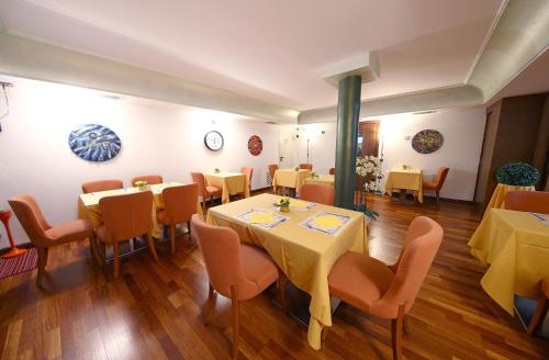 a restaurant with tables and chairs in a room at HR Hotel in Monfalcone