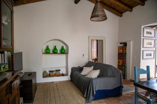 a living room with a couch and green vases on the wall at La Cantina Villa di campagna in Acireale