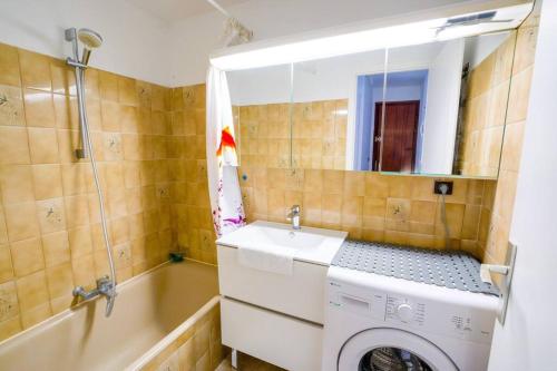 een badkamer met een wasmachine en een wastafel bij CABANA & Les pieds dans l'eau in Duingt