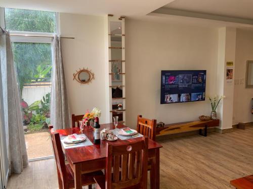 a dining room with a table and a television at Puntakana Apartelle Spacious Apartment Panglao in Panglao
