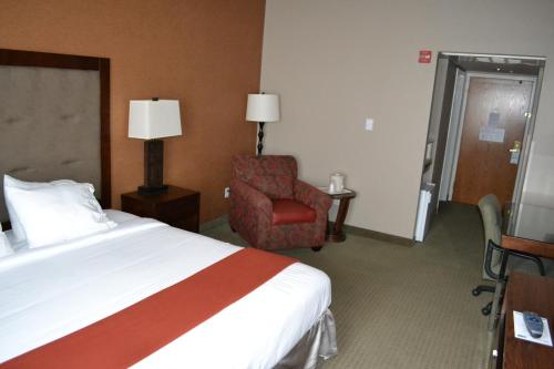 a hotel room with a bed and a chair at Holiday Inn Express & Suites Bozeman West by IHG in Bozeman
