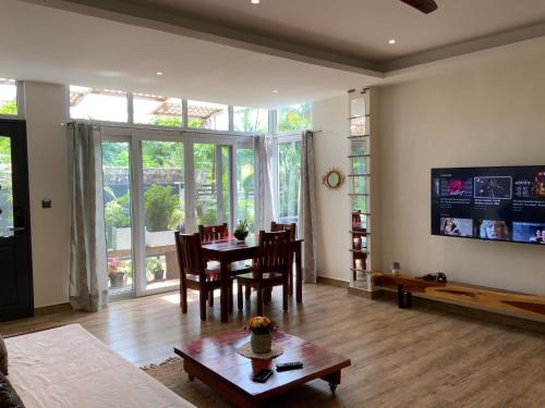 a living room with a table and chairs and a large window at Puntakana Apartelle Spacious Apartment Panglao in Panglao
