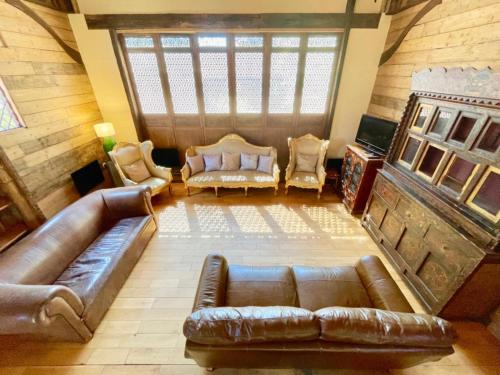 HardhamにあるThe Timber Barn South Downs West Sussex Sleeps 18のリビングルーム(ソファ、椅子付)のオーバーヘッドビュー