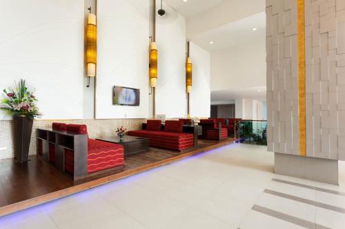 a lobby with red chairs and a couch at Andakira Hotel - SHA Extra Plus in Patong Beach
