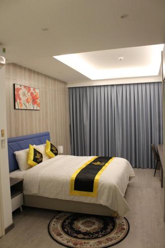a bedroom with a large bed with yellow and black pillows at THE QUEENDOR BOUTIQUE HOTEL in Ho Chi Minh City