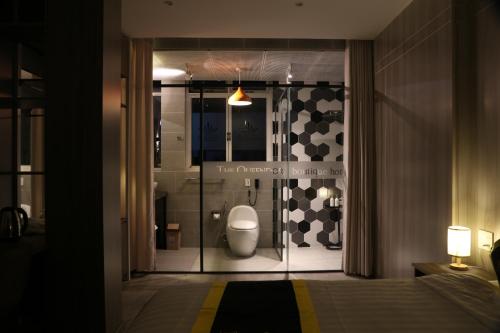 a bathroom with a toilet through a glass door at THE QUEENDOR BOUTIQUE HOTEL in Ho Chi Minh City
