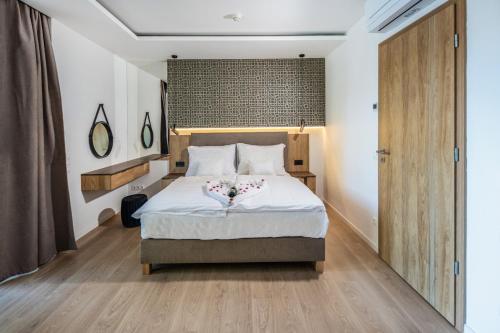 a bedroom with a bed with white sheets and wooden floors at H55 in Balatonlelle
