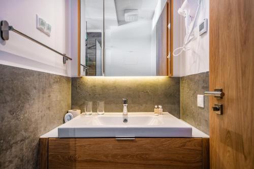 a bathroom with a white sink and a mirror at H55 in Balatonlelle