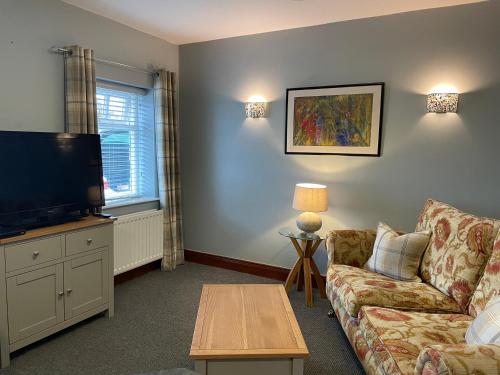 a living room with a couch and a flat screen tv at Milecastle Inn on Hadrian's Wall near Haltwhistle in Haltwhistle