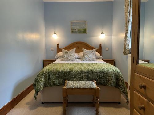 um quarto com uma cama grande e uma colcha verde em Milecastle Inn on Hadrian's Wall near Haltwhistle em Haltwhistle