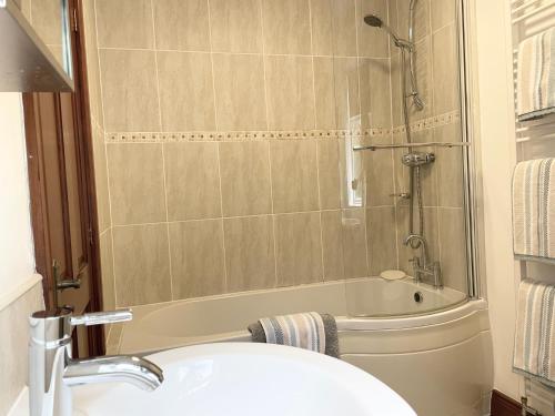 La salle de bains est pourvue d'une douche, d'un lavabo et d'une baignoire. dans l'établissement Milecastle Inn on Hadrian's Wall near Haltwhistle, à Haltwhistle