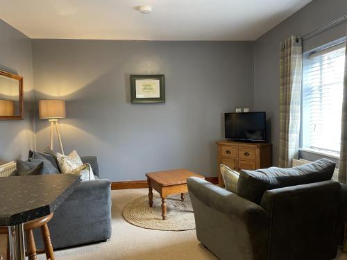 a living room with two couches and a tv at Milecastle Inn on Hadrian's Wall near Haltwhistle in Haltwhistle