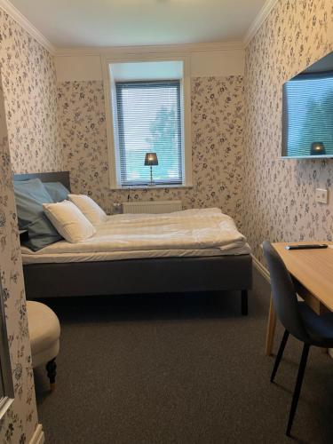 a small bedroom with a bed and a window at Norrfly Herrgård in Kilafors