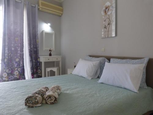 a bedroom with a bed with two towels on it at Golden Keys Apartment ground floor in Moraitika