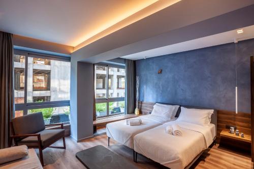 um quarto com uma cama grande e uma parede azul em Katouni25 Luxury Suites em Tessalônica