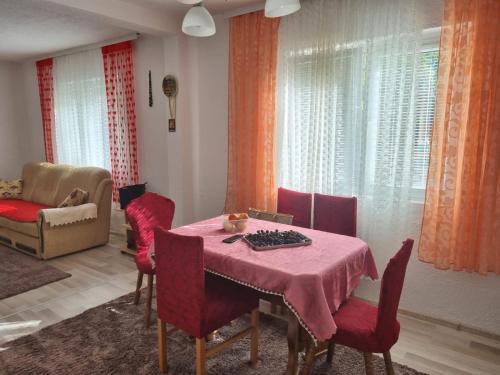 une salle à manger avec une table et des chaises roses dans l'établissement Apartment Nura, à Bihać