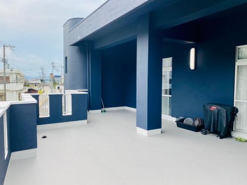 un edificio blu con i bagagli seduti su un balcone di AZホテル南あわじ/1組限定/貸切 a Minamiawaji