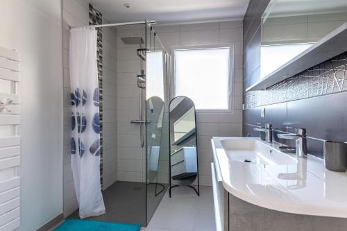 La salle de bains est pourvue d'un lavabo et d'une douche. dans l'établissement La Villa d'Ezer - Maison contemporaine 4-6 pers, à Loctudy