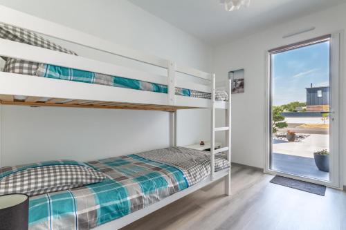 une chambre avec lits superposés et une fenêtre dans l'établissement La Villa d'Ezer - Maison contemporaine 4-6 pers, à Loctudy