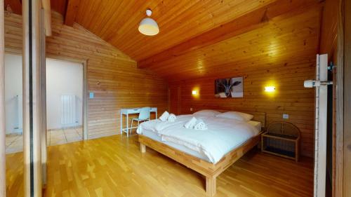 ein Schlafzimmer mit einem Bett in einem Holzzimmer in der Unterkunft 5min. from the ski slopes Crans-Montana, 2 bedrooms, covered parking in Crans-Montana
