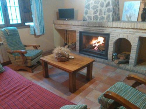 a living room with a fireplace and a coffee table at CASAS RURALES LA TOBICA in Yeste