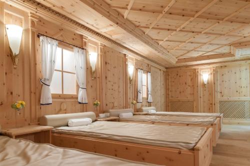 sypialnia z 2 łóżkami i drewnianymi ścianami w obiekcie Regina Hotelsuites w Solden