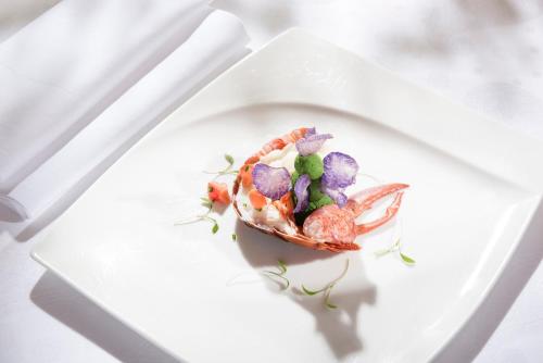 a seafood dish on a white plate on a table at Hotel Das Rübezahl in Schwangau