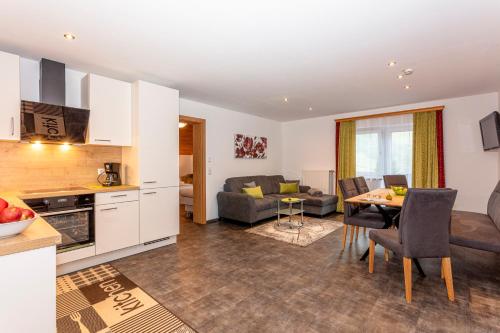 a kitchen and living room with a table and chairs at Frühstückshotel Birkenhof in Rauris