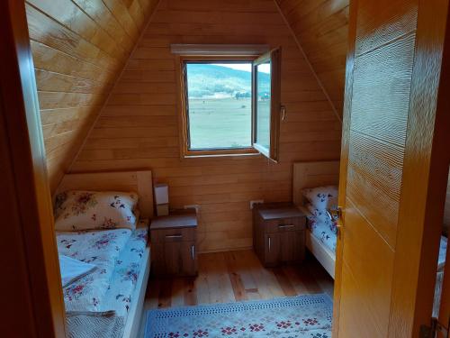 una piccola camera con due letti e una finestra di Vule bungalovi a Žabljak