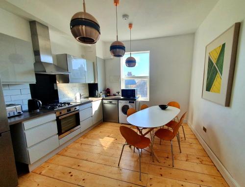 a kitchen with a table and chairs in it at Sunny Apartment with a 10 minute walk to the Sea. in Kent
