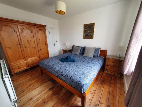 Un dormitorio con una cama y suelo de madera. en Sunny Apartment with a 10 minute walk to the Sea., en Kent