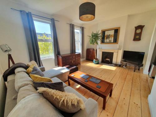 a living room with a couch and a table at Sunny Apartment with a 10 minute walk to the Sea. in Kent