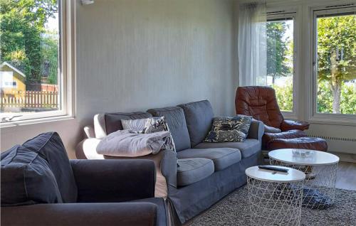a living room with a blue couch and two chairs at Nice Home In Ljungby With Wifi in Ljungby
