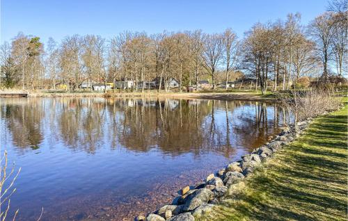 a large lake with trees and houses in the background at Nice Home In Ljungby With Wifi in Ljungby