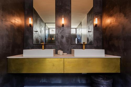 a bathroom with two sinks and two mirrors at Villa Pietra - Camps Bay in Cape Town