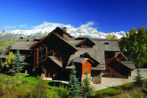 a large log house with mountains in the background at Mountain Lodge Telluride in Telluride