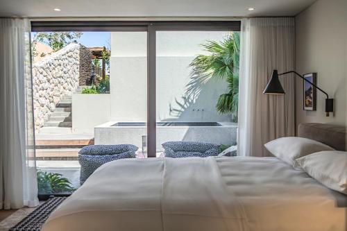 a bedroom with a bed and a large window at Villa Pietra - Camps Bay in Cape Town