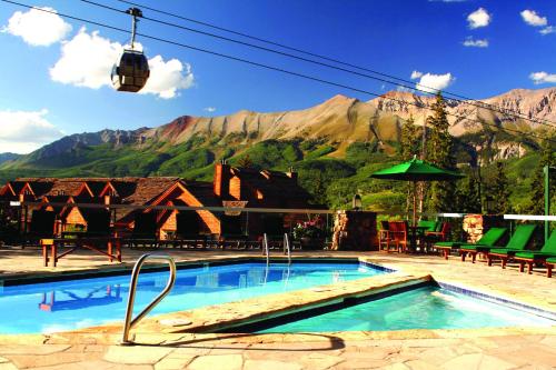 a resort swimming pool with a mountain in the background at Mountain Lodge Telluride in Telluride
