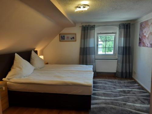 a bedroom with a bed and a window at Haus Rauschenbach in Rauschenbach