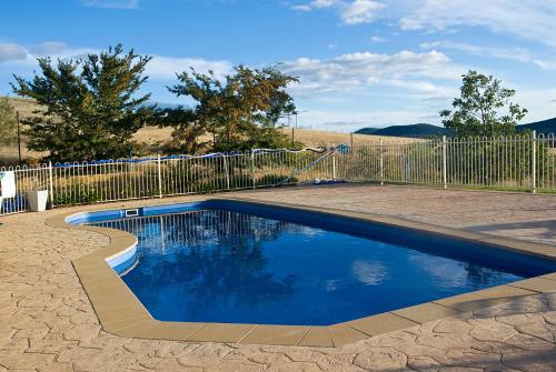 a swimming pool in a yard next to a fence at Hermitage Hill Country Retreat in Wellington