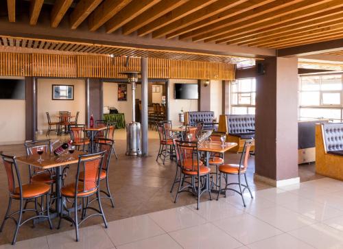 um restaurante com mesas e cadeiras num quarto em Eton Hotel em Thika