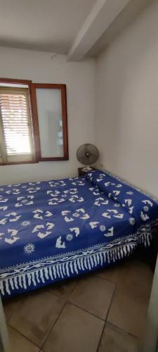 a bedroom with a bed with a blue blanket with animals on it at Terra è mare in San Teodoro