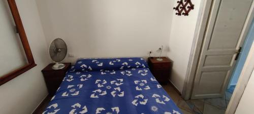 a bedroom with a bed with a blue bedspread with white horses on it at Terra è mare in San Teodoro