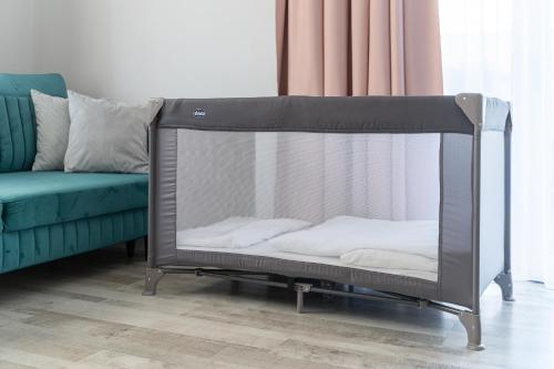 a crib in a living room next to a couch at Silver Apartments in Świnoujście