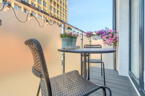 a table and chairs on a balcony with flowers at Silver Apartments in Świnoujście