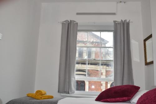 una ventana con un osito de peluche sentado en la parte superior de una cama en Camri Room en Denbigh